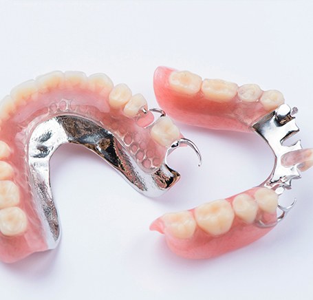Two arches of partial dentures with white background