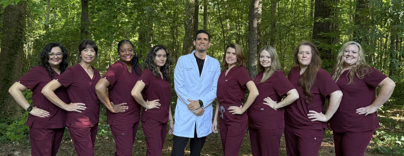 Smiling Durham dental team standing in front of Crafting Smiles