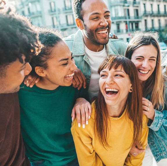 Patient in Durham smiling confidently with friends after veneer treatment