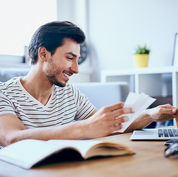 Patient in Durham smiling as they do paperwork for veneers financing