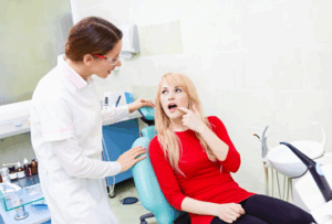 Patient pointing to her mouth and explaining symptoms to dentist