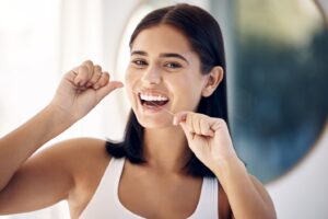 Woman flossing her teeth.